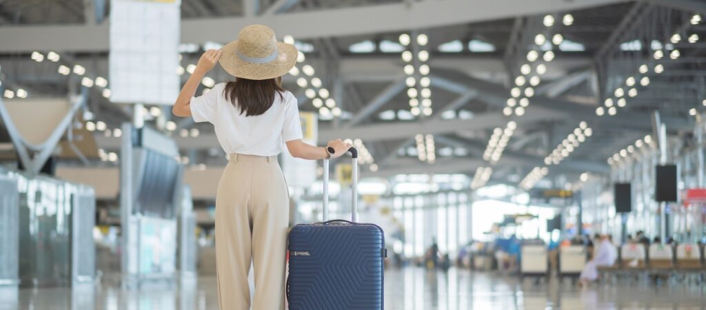 Young woman tourist at international airport terminal. Time to travel, trip and vacation concepts